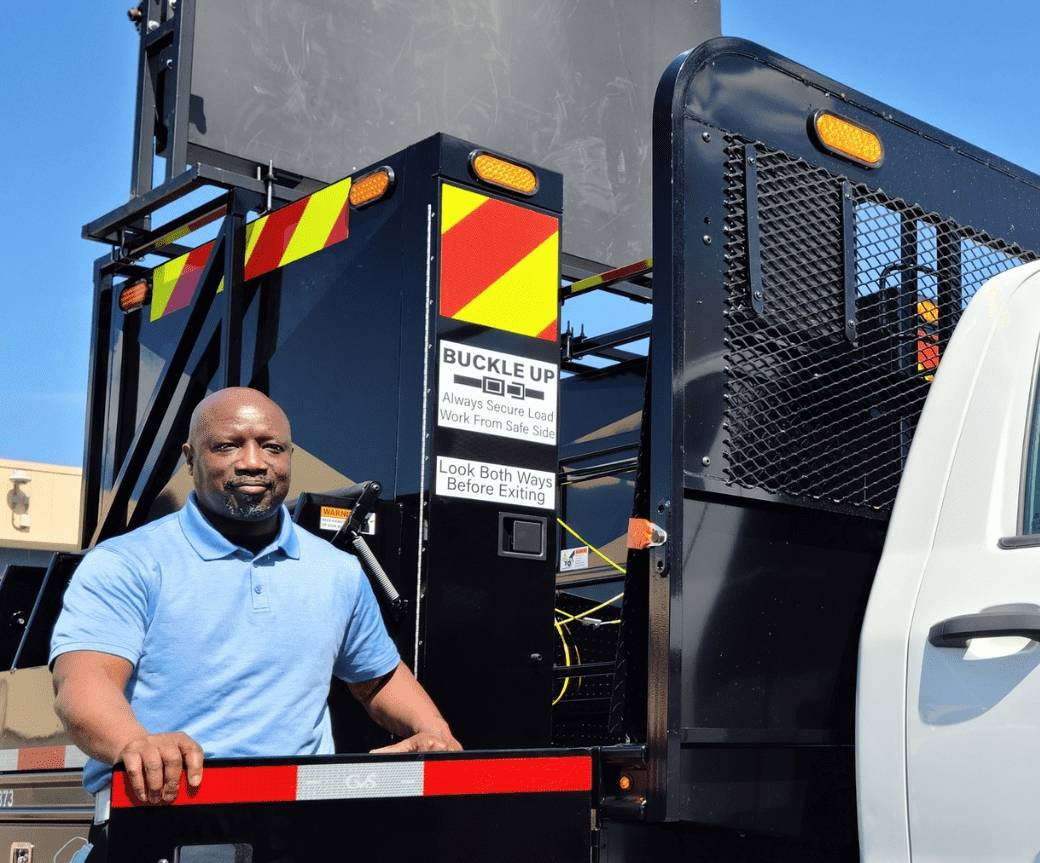 a man wearing blue shirt operating the truck